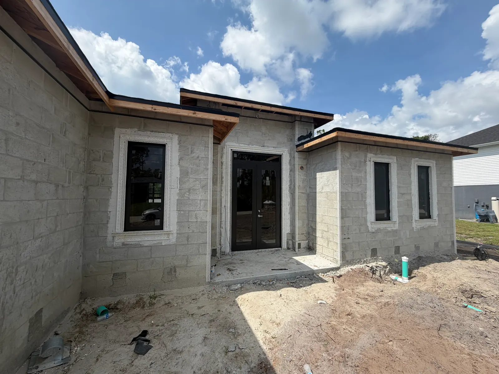 Casa de bloque en construcción bajo un cielo con nubes