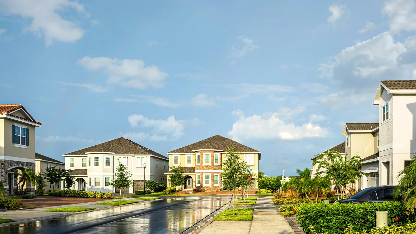 Casas nuevas de dos plantas con palmeras en una calle residencial de Florida Central